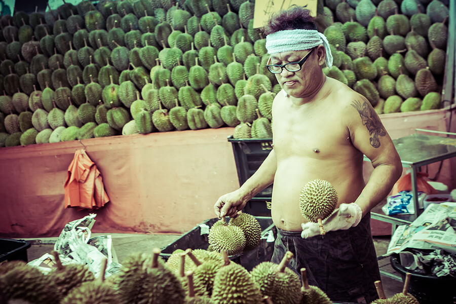 Durian vendor at fruit stand.