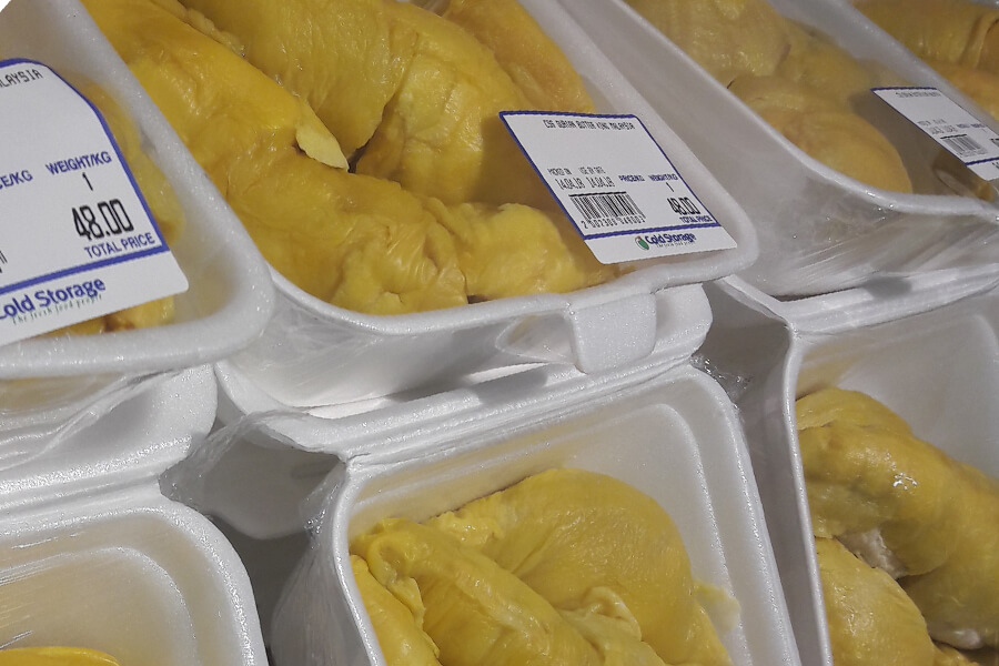 Individual durian pieces, pre-packaged in saran wrap and styrofoam.