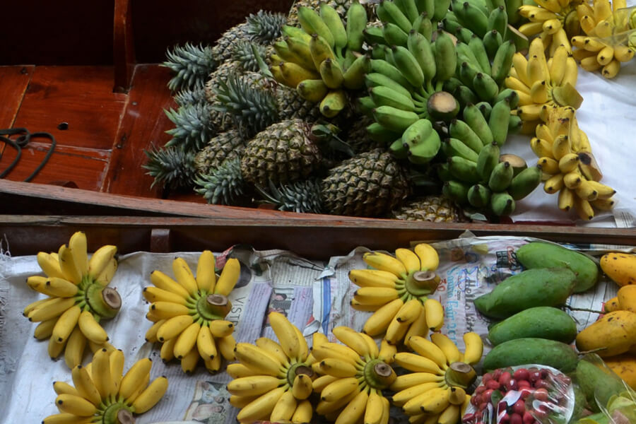Bunches of Thai bananas and other tropical fruits (pineapple, mango, papaya, etc.), on a Thai river boat.