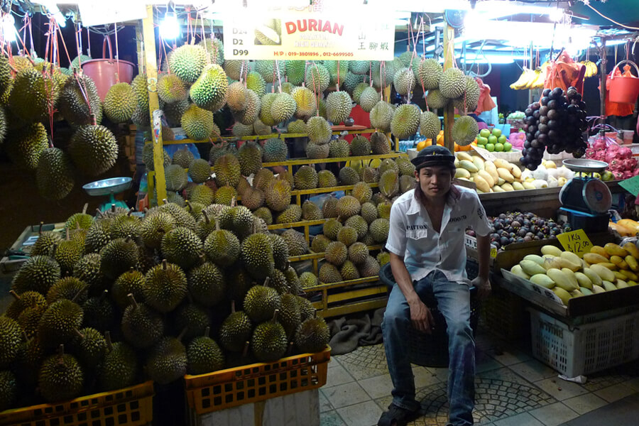 Durian vendor at fruit stand.